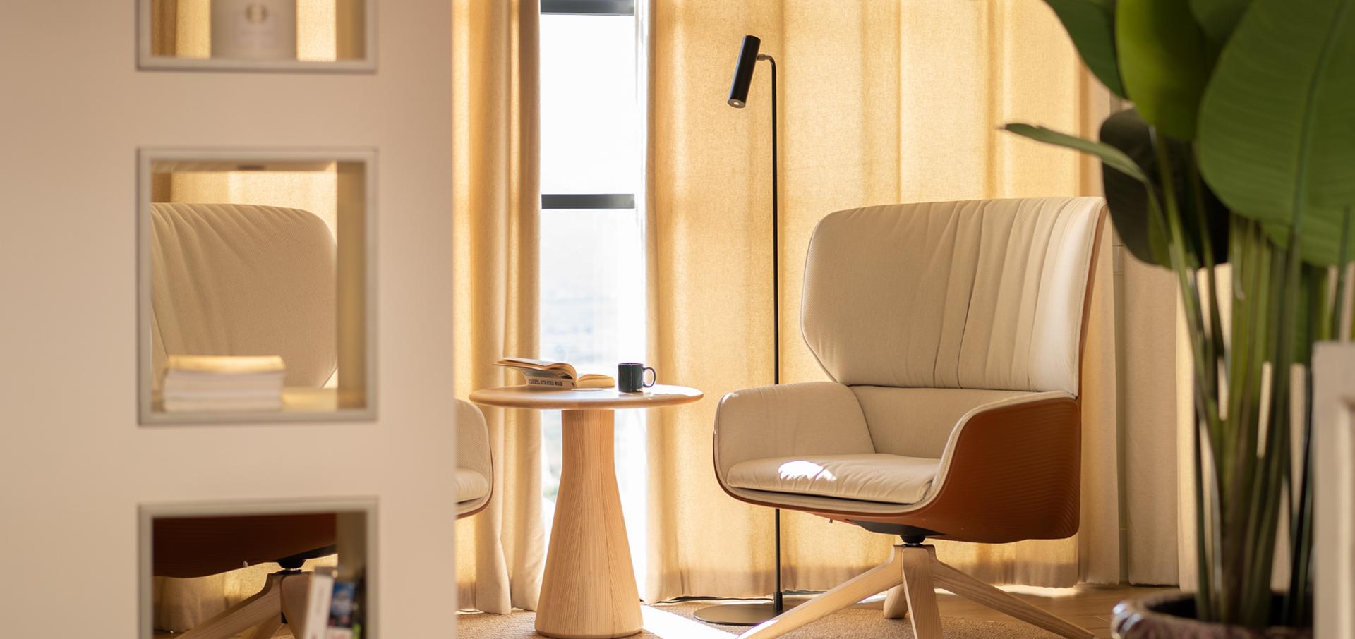 Salón de diseño minimalista creado por los mejores estudios de interiorismo en Alicante con sillón beige y mesa de madera.